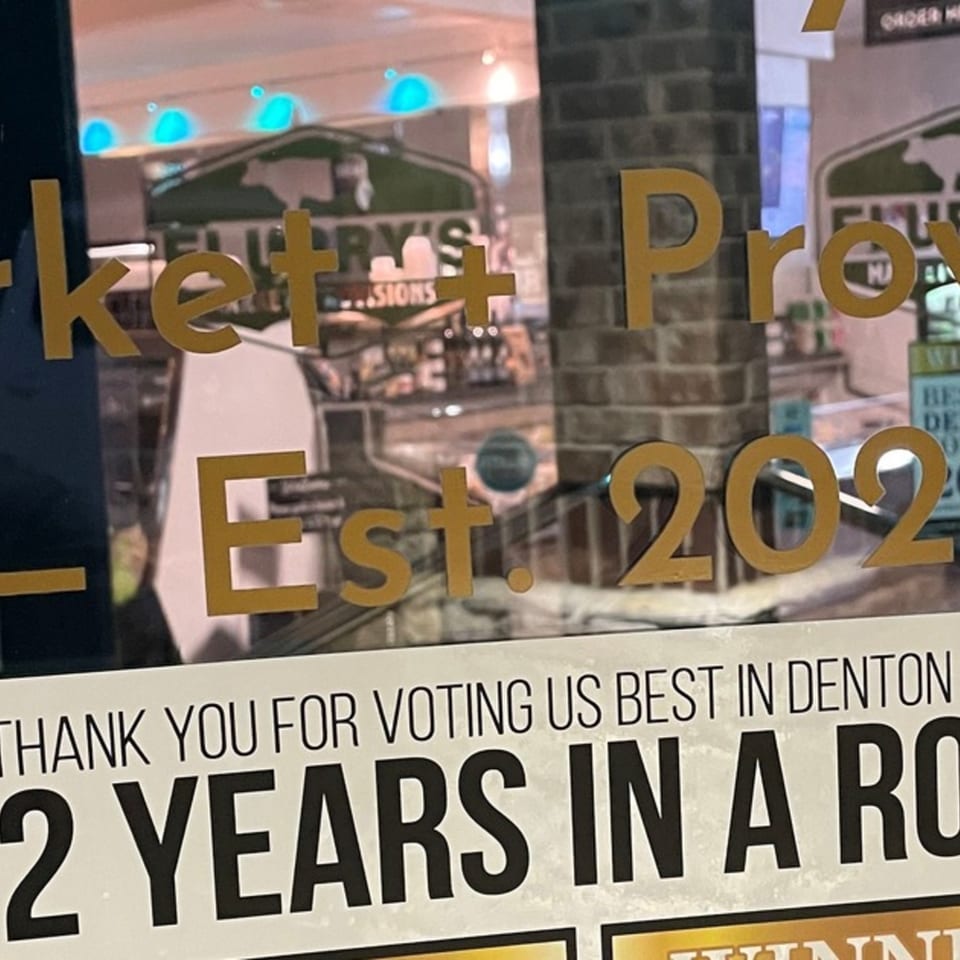 Flurry's Market Lakeside deli window with "Est. 2022" and "Best in Denton 2 Years in a Row" signs.